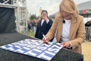 Tompa Enikő dedikálja a tiszás plakátokat